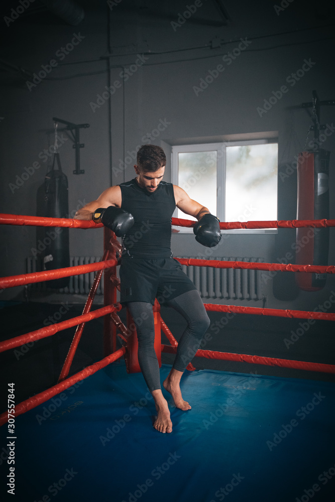 In a boxing ring athletic man have a break time after a boxing workout , he are brutal and very concentrated In a boxing ring athletic man have a break time after a boxing workout , he are brutal and very concentrated