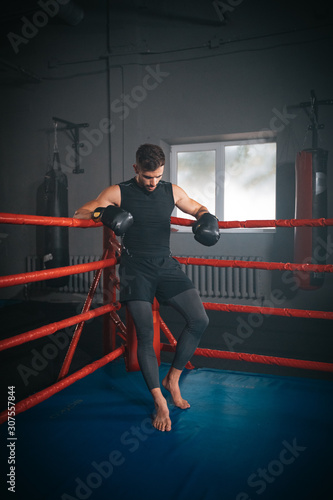 In a boxing ring athletic man have a break time after a boxing workout , he are brutal and very concentrated