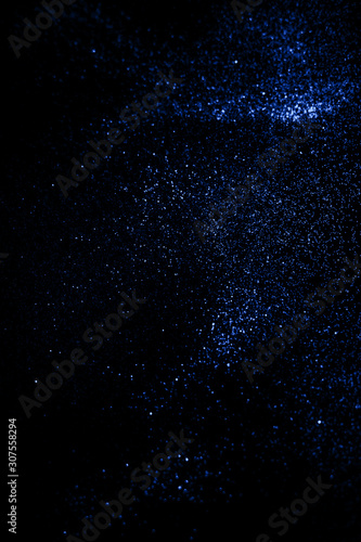 Classic shiny black background with blue glitter .
