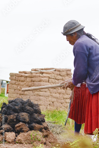 Native american woman cooking in the huatia - traditional eathern oven. photo