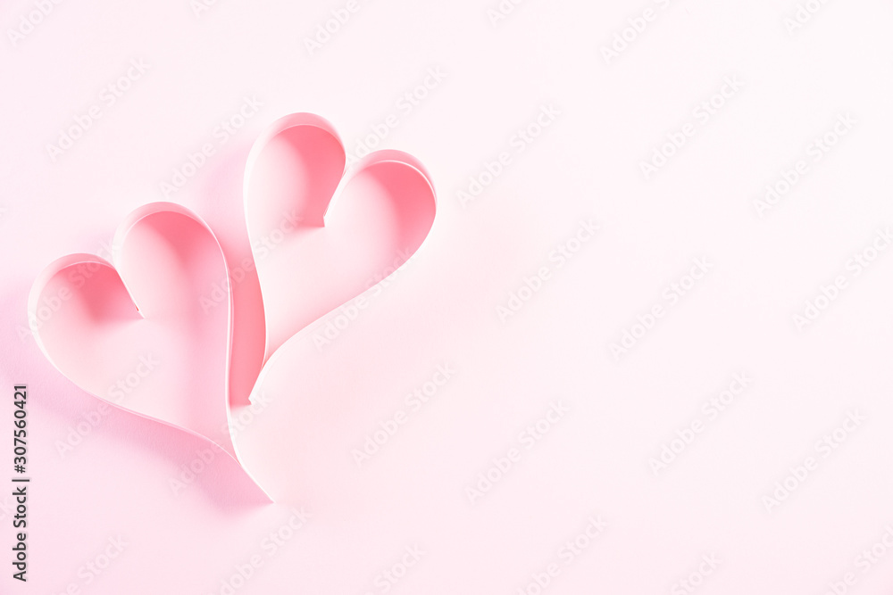 Two pink paper hearts on Light pink pastel paper background. Love and Valentine's day concept. Two pink paper hearts on Light pink pastel paper background. Love and Valentine's day concept.