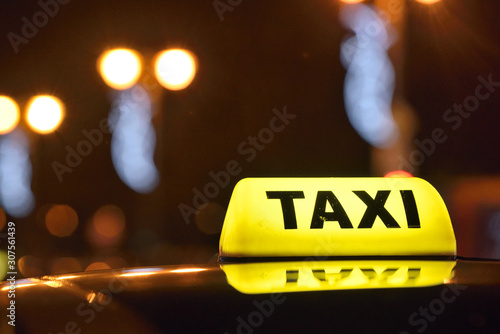 An yellow taxi sign at night