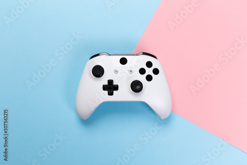 White joystick gamepad, game console on pink and blue background. Computer gaming technology play competition videogame control confrontation concept. Cyberspace symbol