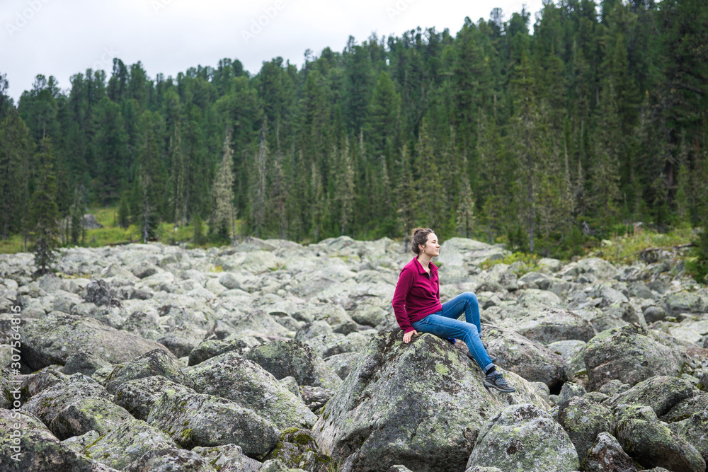a girl on the background of nature, sitting on a mountain