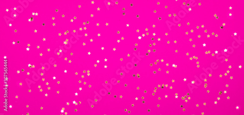 gold stars on pink crimson Magenta background Festive holiday background. Celebration concept. Top view,