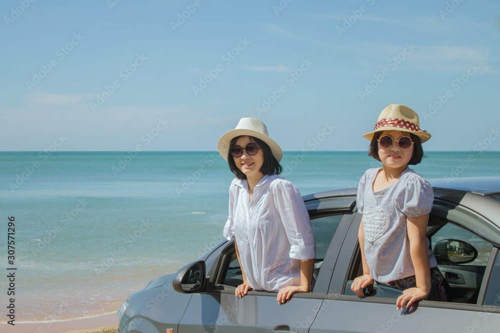 Summer Vacation and Car Trip Concept : Family car trip at the sea, Woman and child cheerful in car with seascape in the background, They feeling happiness.