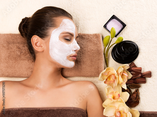 Young woman with mask on her face relaxing in the spa salon.