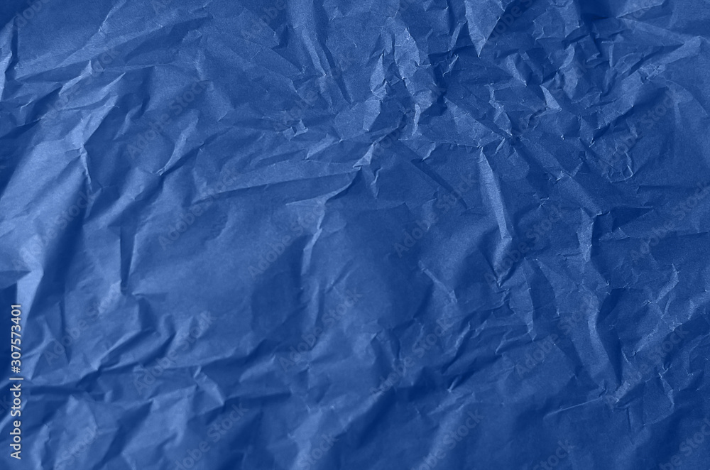 Textured crumpled paper in blue. Background for your design. Tinted paper.