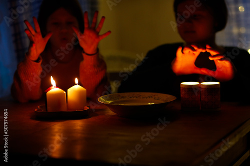 Magic two children guess with candles in the dark