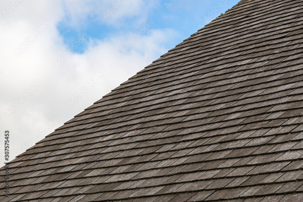 Grey slate roof with cloudy blue sky background