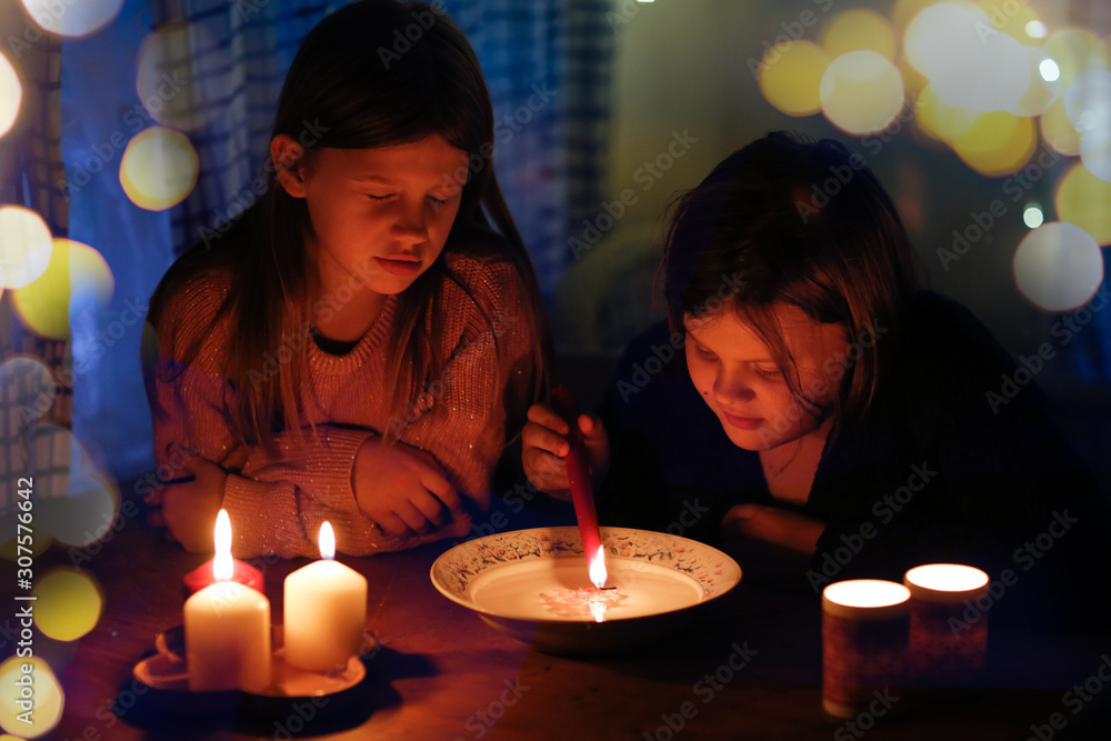 Magical two children divine with candles in dark Magical two children divine with candles in dark