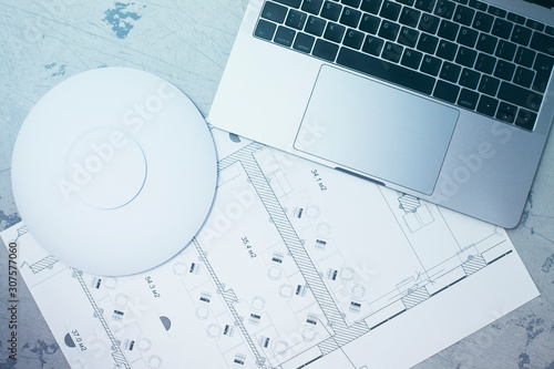 Engineering process. Man developing a network diagram for wifi access in cafe. Access point, floor layout, laptop and man hand on the bright background. Space for your text.