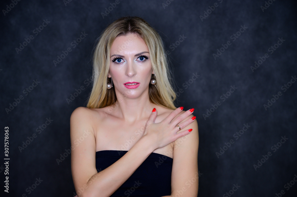 Artistic portrait of a pretty slim blonde model with excellent makeup and beautiful hair in a black top on a gray background. Stylish, fashionable, youth, sexy. This is in different poses. Artistic portrait of a pretty slim blonde model with excellent makeup and beautiful hair in a black top on a gray background. Stylish, fashionable, youth, sexy. This is in different poses.