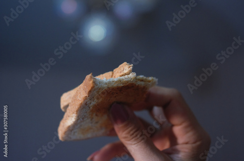 Woman holding a toasted bread with bite marks