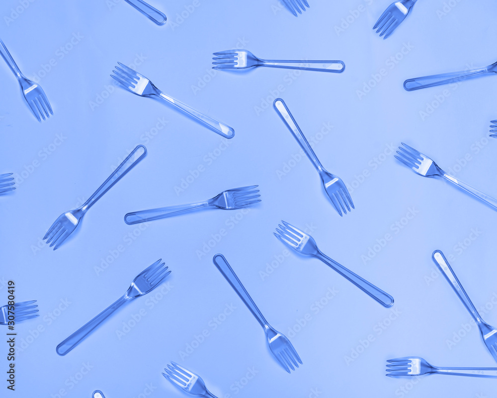 Plastic fork pattern on classic blue background. Concept of color 2020. Plastic fork pattern on classic blue background. Concept of color 2020.