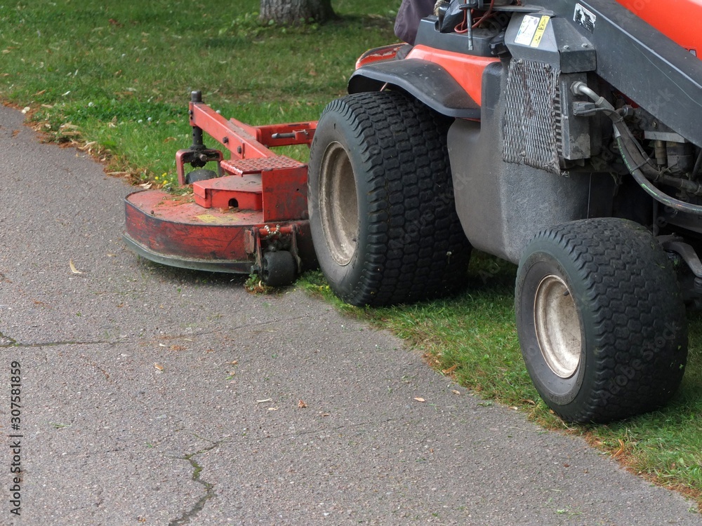 cutting the grass of on a tractor lawn mower cutting the grass of on a tractor lawn mower