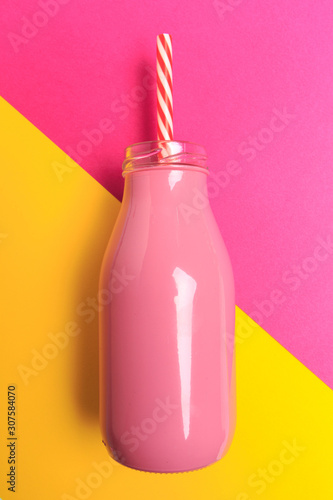 colorful bottle with straw on color background . Minimalism concept - Image photo