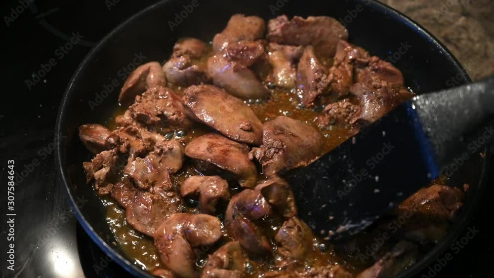 Homemade chicken liver with sauce fried in a frying pan and stirred with a spatula Homemade chicken liver with sauce fried in a frying pan and stirred with a spatula