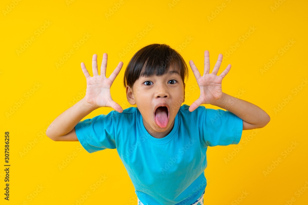 Portrait of young Asian girl expression and joyful, Thai kid have fun and innocence on yellow background Portrait of young Asian girl expression and joyful, Thai kid have fun and innocence on yellow background