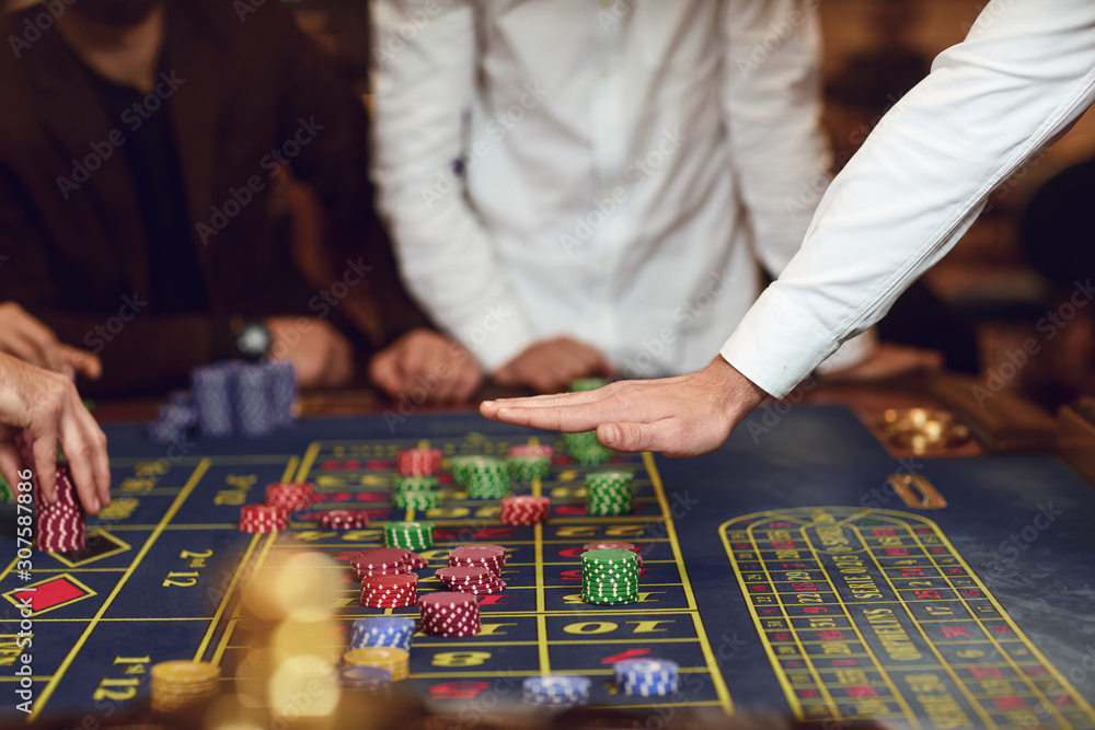 Croupier's hand gesture on the table with roulette chips. Croupier's hand gesture on the table with roulette chips.