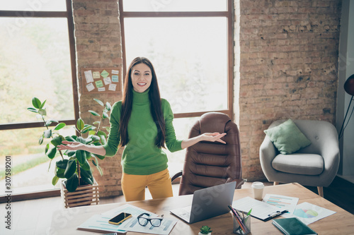 Photo of pretty business lady meet partners friendly smiling important company guests need take money investment wear green turtleneck yellow trousers modern interior office