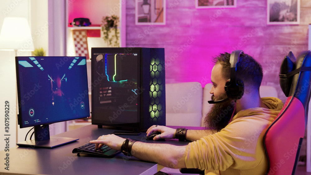 Bearded man playing online video games on his pc Bearded man playing online video games on his pc