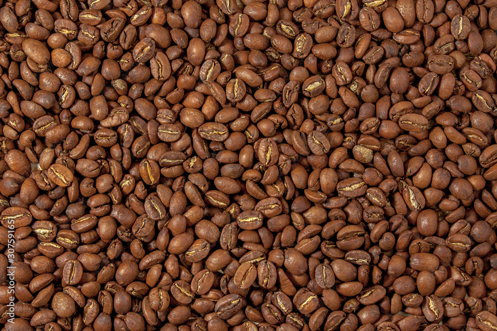 Background from tightly poured coffee beans. View from above. Background from tightly poured coffee beans. View from above.