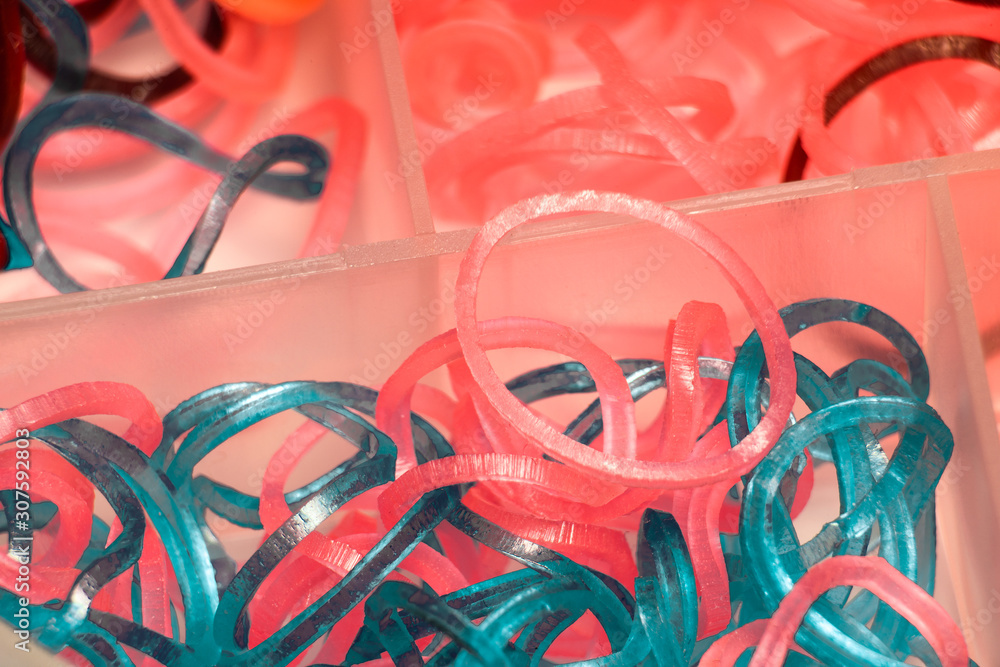 Thin rubber bands for hair in a plastic box, soft focus