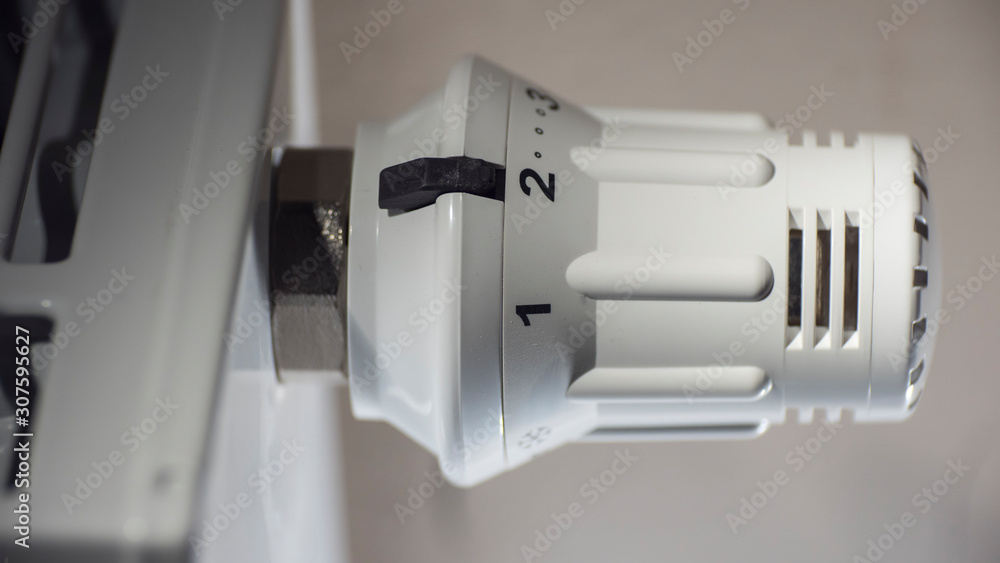 Close-up of a thermostat with a scale on a steel heating radiator Close-up of a thermostat with a scale on a steel heating radiator