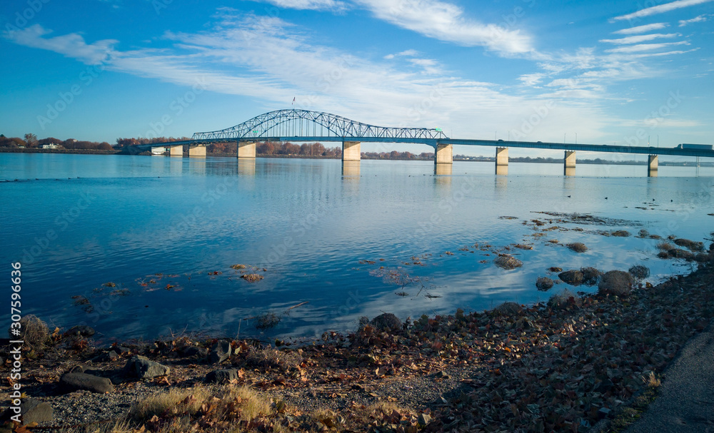Historic blue and white arch truss bridge over the Columbia River with blue skies and clouds on a sunny morning in Kennewick-Pasco Washington Historic blue and white arch truss bridge over the Columbia River with blue skies and clouds on a sunny morning in Kennewick-Pasco Washington
