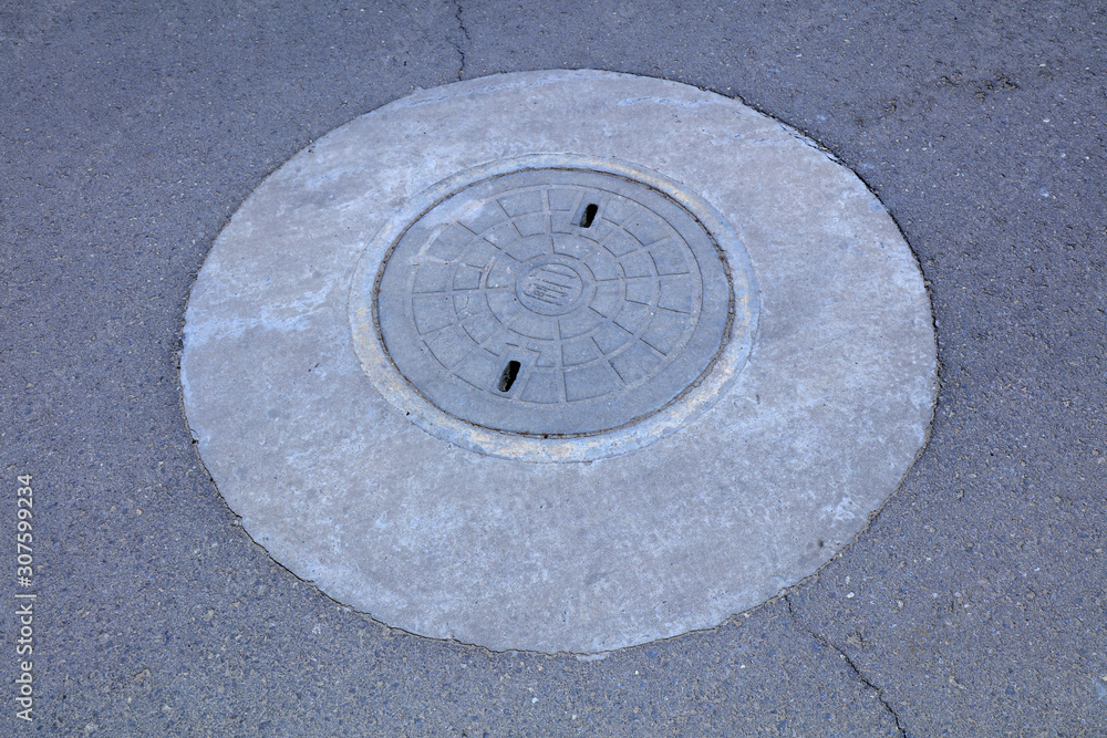 Municipal well covers on the asphalt road