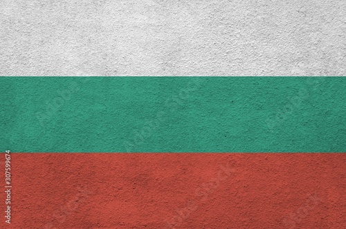 Bulgaria flag depicted in bright paint colors on old relief plastering wall. Textured banner on rough background photo