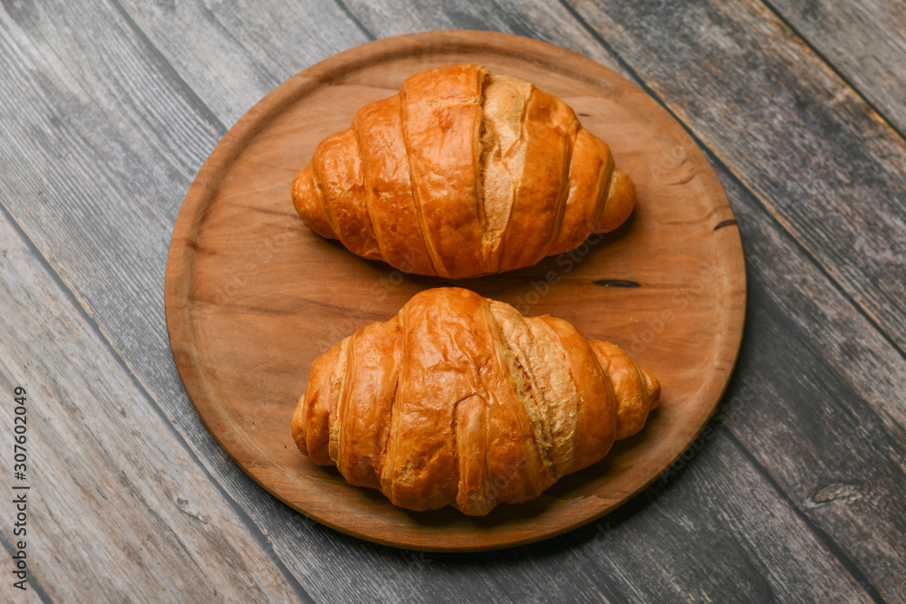 two croissants. Fresh french croissant. on a wooden background. View from above. Morning breakfast with a croissant. French breakfast. Great homey. Fresh tower. two croissants. Fresh french croissant. on a wooden background. View from above. Morning breakfast with a croissant. French breakfast. Great homey. Fresh tower.