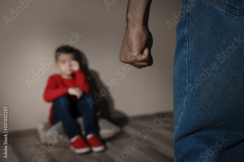 Man threatening his son indoors, closeup. Domestic violence concept