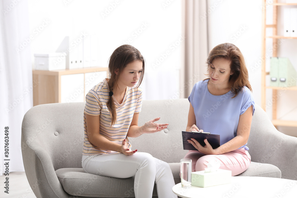 Psychotherapist working with teenage girl in office Psychotherapist working with teenage girl in office