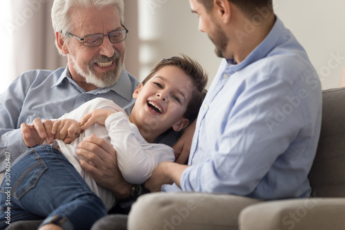 Cheerful grandfather son and grandson having fun at home photo