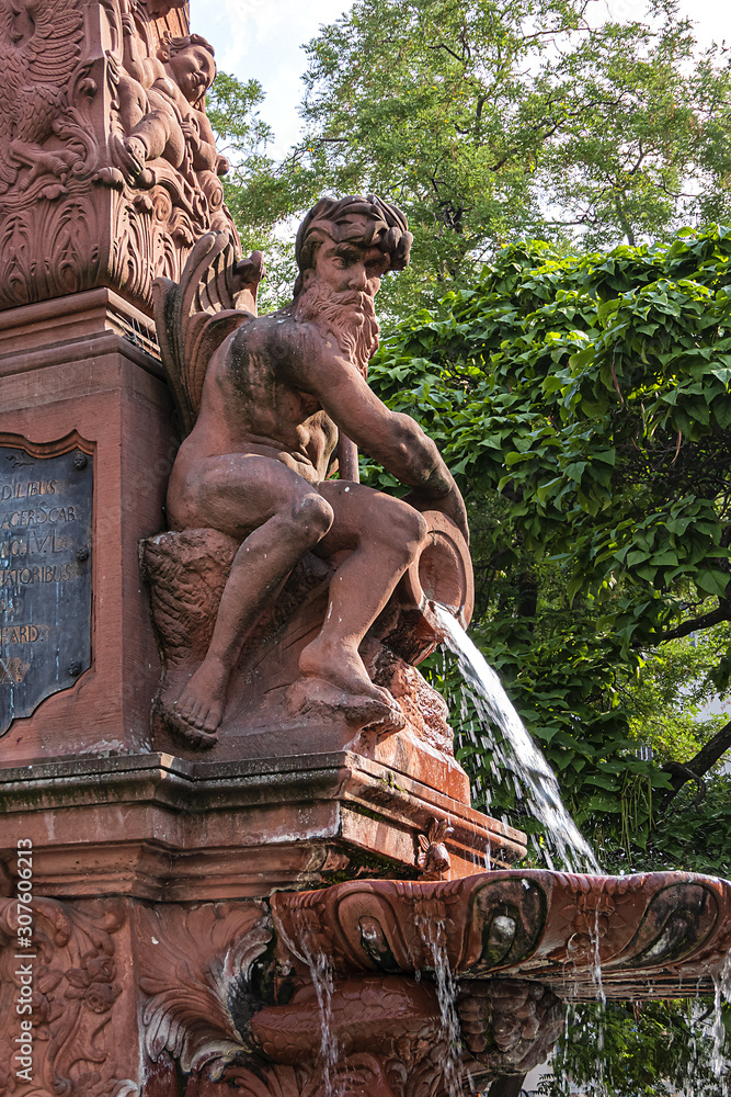 Late baroque fountain Liebfrauenberg-Brunnen, build in 1770. In center of an oval fountain basin stands a rusticated obelisk with baroque decorative elements. Frankfurt am Main, Germany.