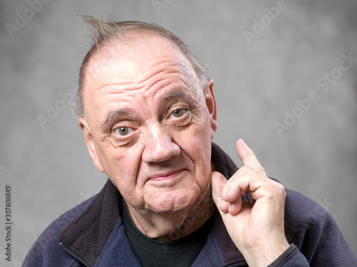 Portrait vieil homme gesticulant sur fond gris