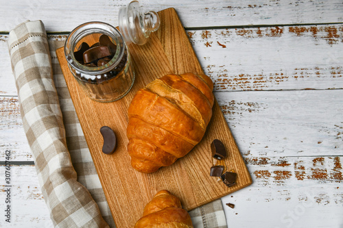 french chocolate croissants top view. the beginning of the morning. Fresh french croissant. Coffee cup and fresh baked croissants on a wooden background. View from above.