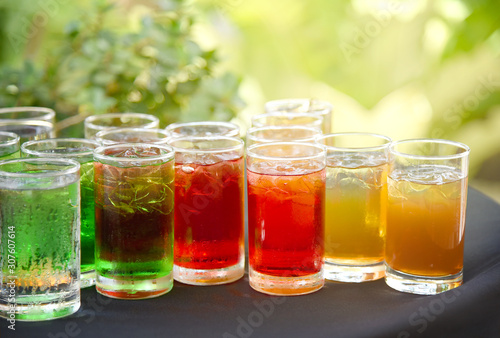 Принти на полотні Glass of soft drinks with ice  served on table in garden
