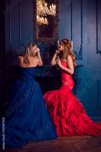 Gorgeous Women, ladies in perfect evening dreses with feathers and sparkle at living room, Holidays time photo