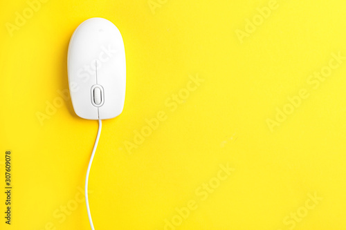 Modern wired optical mouse on yellow background, top view. Space for text
