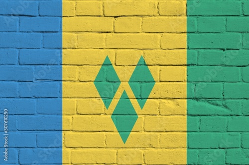 Saint Vincent and the Grenadines flag depicted in paint colors on old brick wall. Textured banner on big brick wall masonry background photo