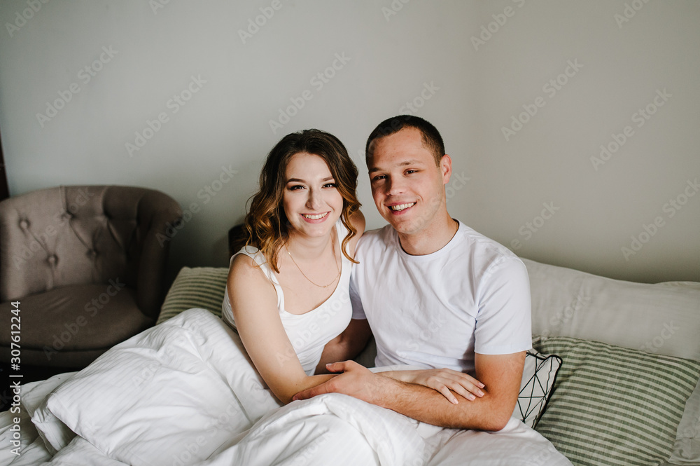 Happy family portrait, concept of a family holiday. Close up. Emotions of happiness. Loving couple hugging on bed in the bedroom. Happy family portrait, concept of a family holiday. Close up. Emotions of happiness. Loving couple hugging on bed in the bedroom.