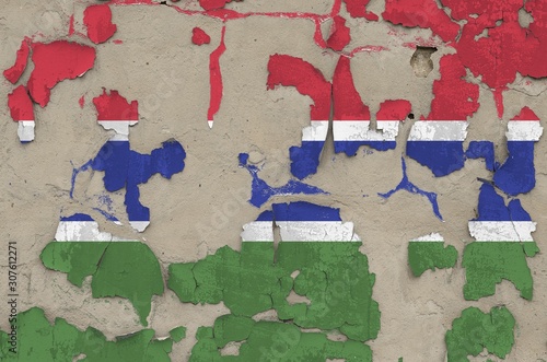 Gambia flag depicted in paint colors on old obsolete messy concrete wall closeup. Textured banner on rough background photo