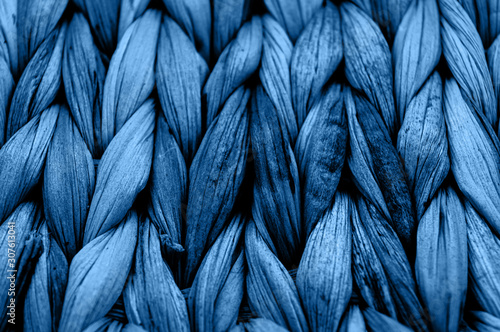 Rustic natural wicker texture toned in classic blue monochrome color. Braided pattern macro photography.