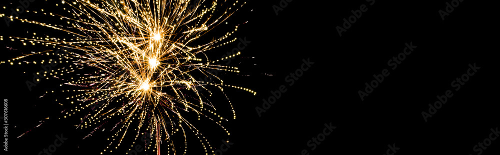 Obraz premium Panoramic shot of golden festive fireworks in night sky, isolated on black