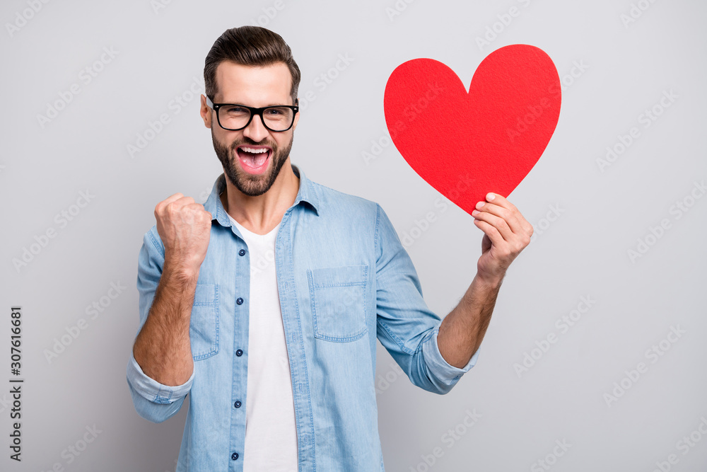 Photo of crazy glad handsome guy holding large red paper heart pretty girl invited him to prom party overjoyed wear specs casual denim outfit isolated grey color background Photo of crazy glad handsome guy holding large red paper heart pretty girl invited him to prom party overjoyed wear specs casual denim outfit isolated grey color background