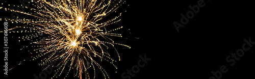 Panoramic shot of golden festive fireworks in night sky, isolated on black