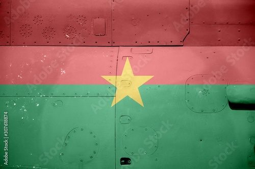 Burkina Faso flag depicted on side part of military armored helicopter closeup. Army forces aircraft conceptual background photo